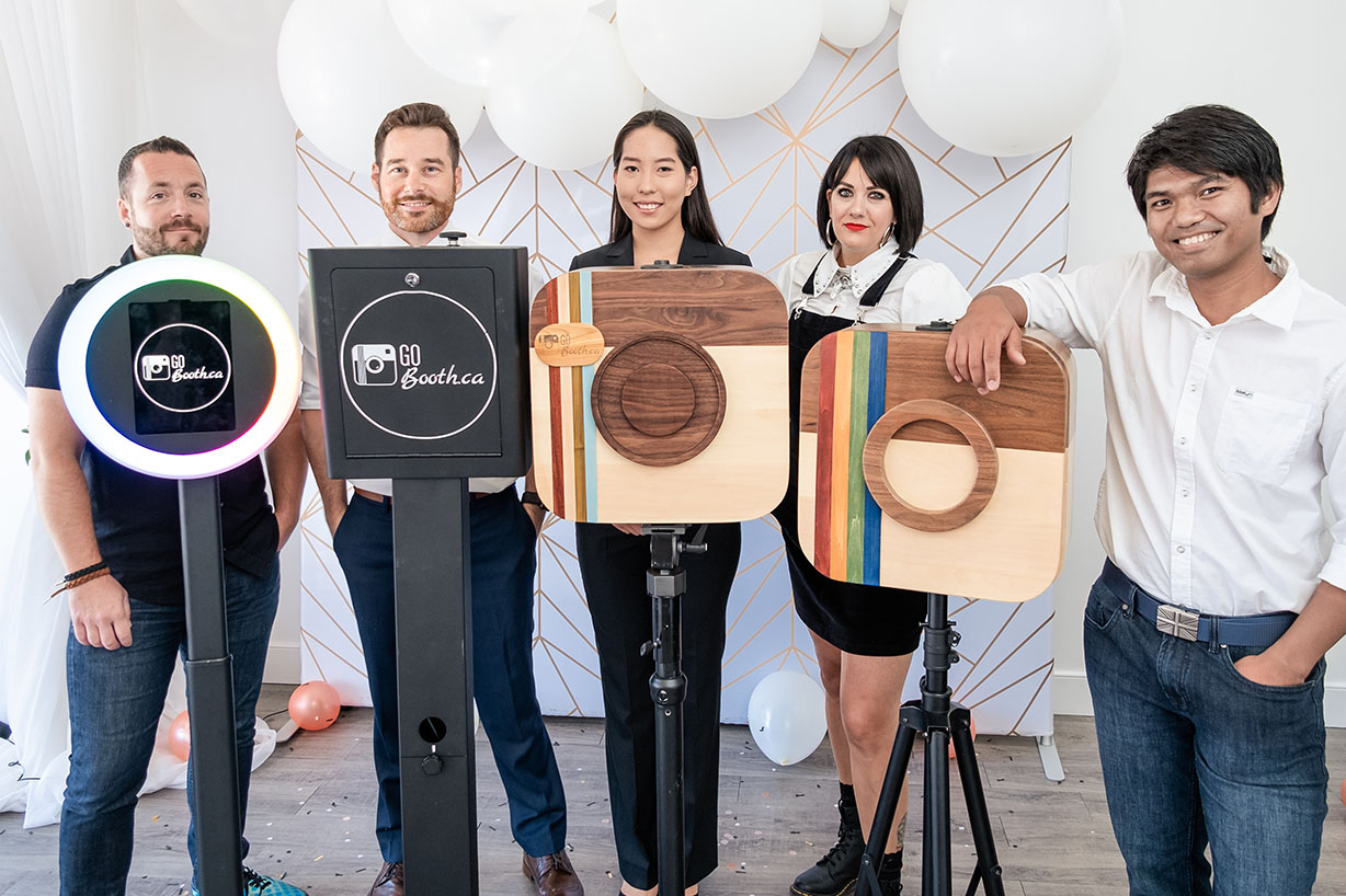 Dan Goneau and the GoBooth team standing with their photo booths