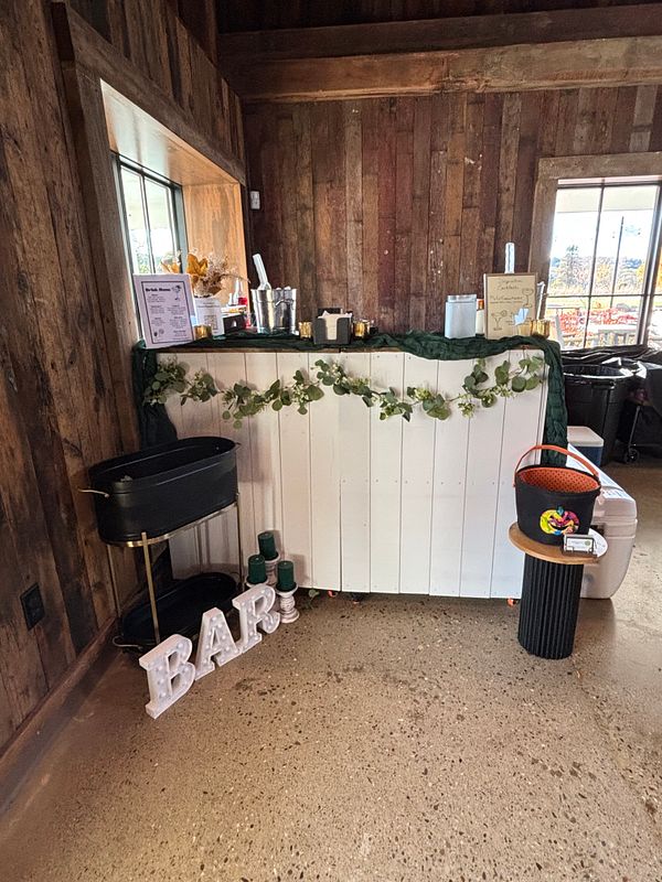 LOak’s Shiplap Bar (Bar on Wheels - L-shaped) and one table behind the bar with fitted tablecloth